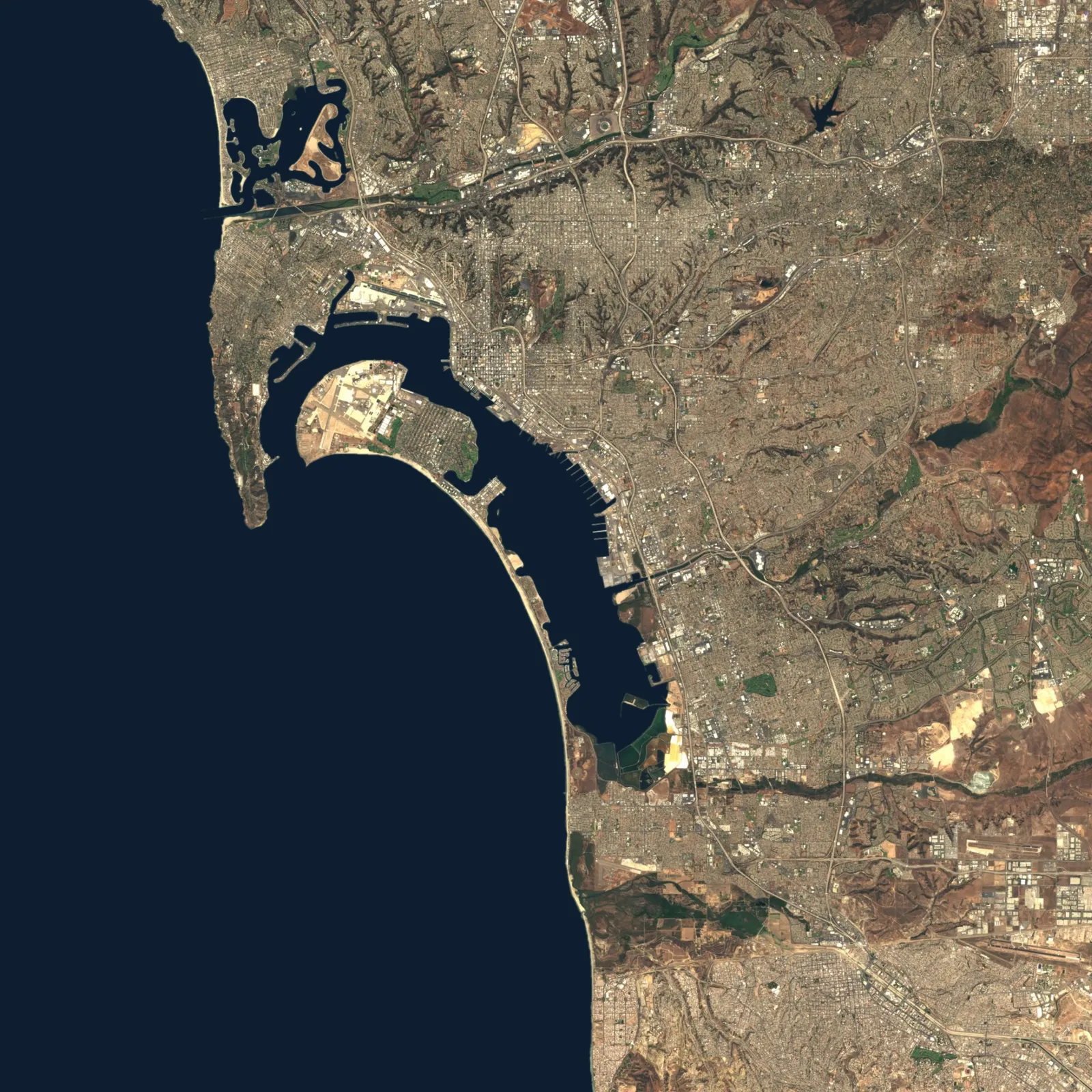 Aerial view of San Diego from Mission Bay to San Diego Bay, with the coastline and freeways traced in orange